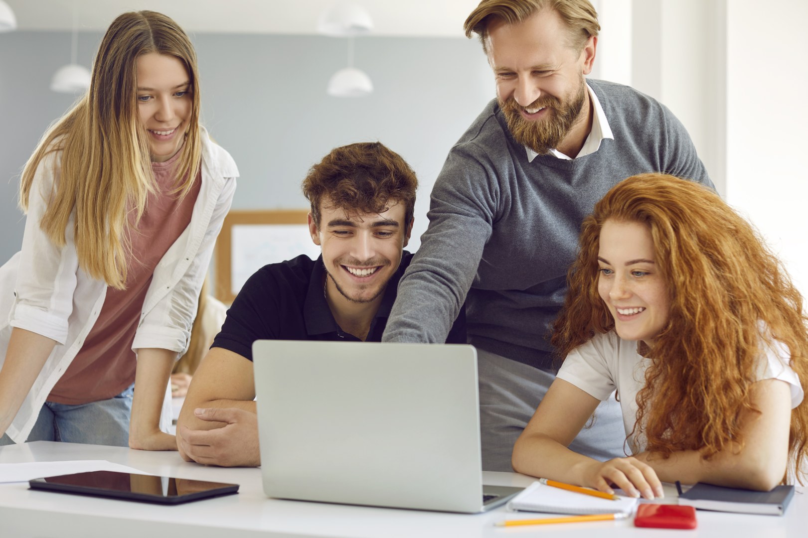 Eine Wissenschaftlerin und ein Wissenschaftler arbeiten hinter einer Glasfassade und mischen Chemikalien mit Großgeräten.