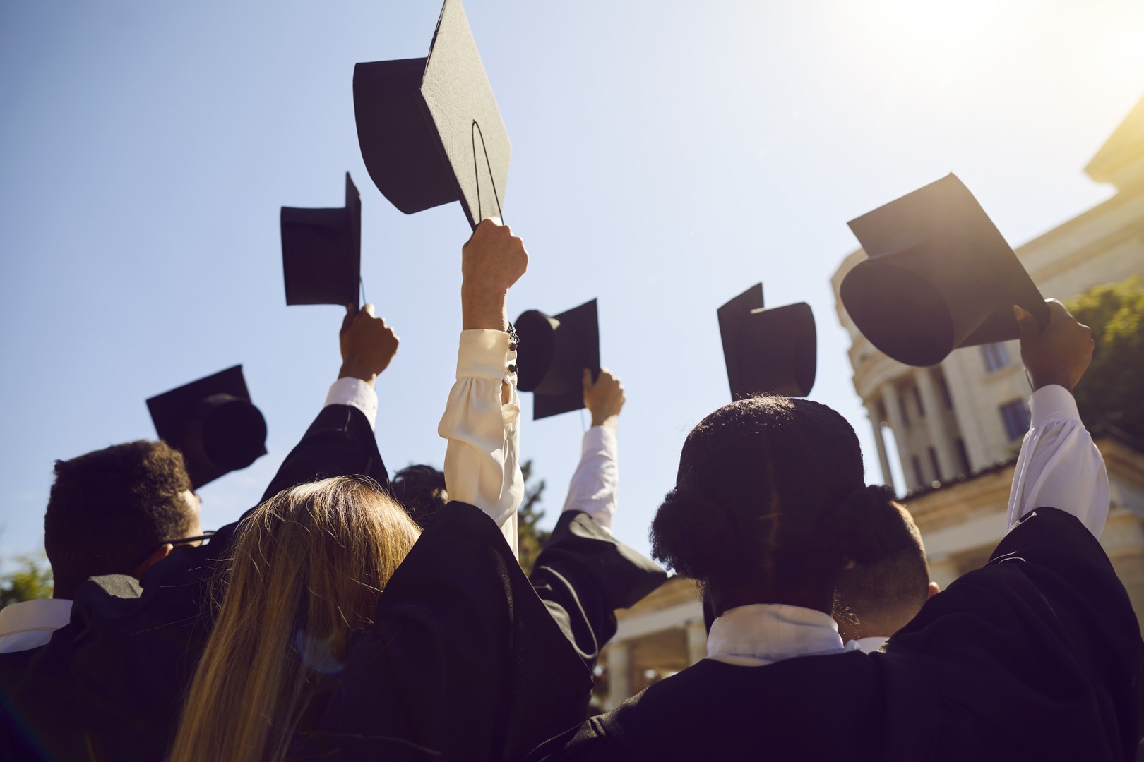Eine Wissenschaftlerin und ein Wissenschaftler arbeiten hinter einer Glasfassade und mischen Chemikalien mit Großgeräten.